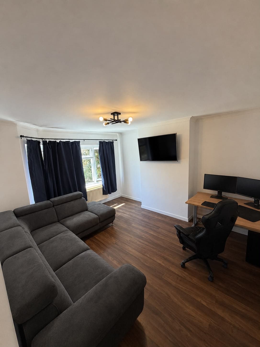 Living room after renovation with new flooring, lighting and repainted walls
